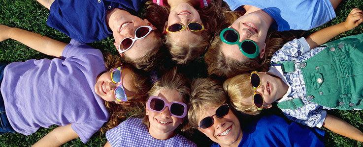 children wearing sunglasses looking up at the camera