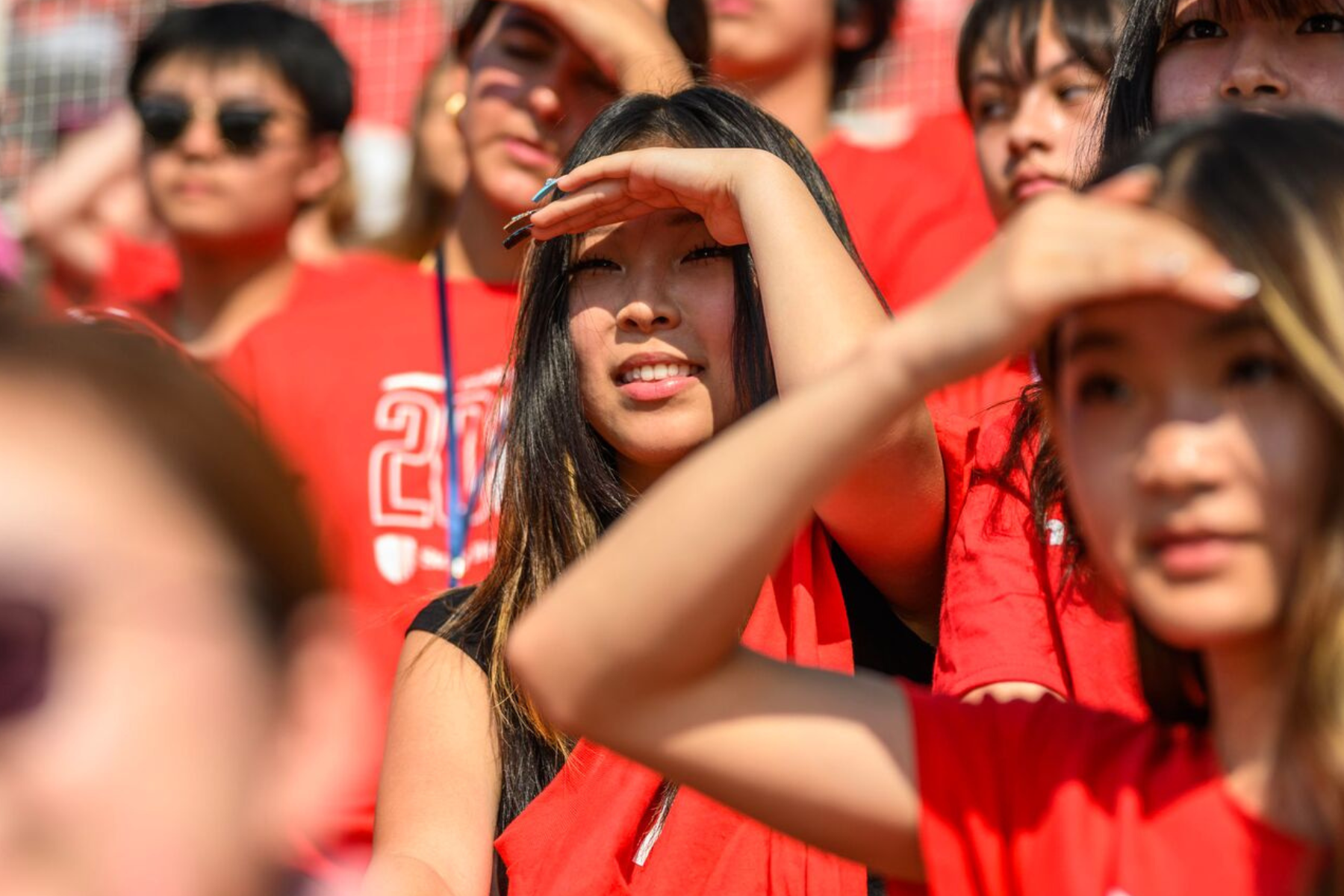 students in the stands of the football stadium on a sunny day